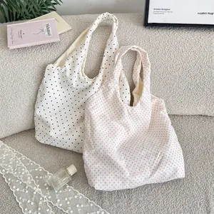 Detailed shot of two polka dot canvas tote bags in white and pink patterns