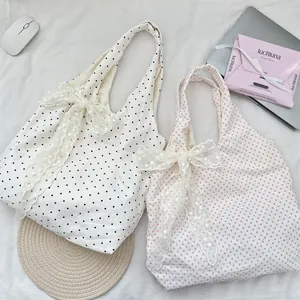 Detailed view of polka dot canvas tote bags with elegant lace bow accents