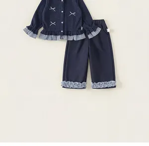 Close-up of girls' navy long-sleeve top and plaid ruffle pants set with bow details