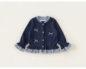 Detailed view of girls navy blue knit cardigan with plaid ruffles and cute bow accents