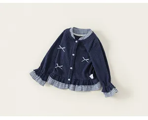 Detailed view of girls' navy knit cardigan with bow accents and plaid ruffles