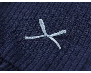 Detailed macro view of a light blue ribbon bow on dark navy ribbed fabric girl's top