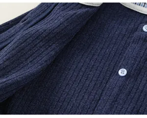 Detail of navy blue ribbed fabric and light blue buttons on a girl's sweet top