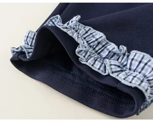Detailed macro shot of navy blue girls jacket with blue plaid ruffled cuff design