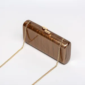 Detailed macro view of the brown marble acrylic texture and gold metal clasp on this bag