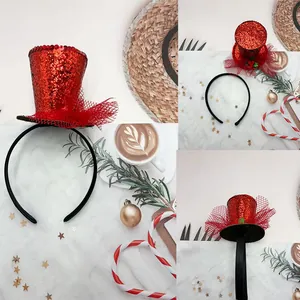 Close-up of red sequin mini top hat headband with lace veil and holly leaf detail