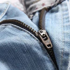 Detail of vintage copper zipper and heavy denim fabric on light blue denim shorts