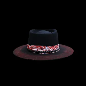 Détail de chapeau en laine à bord large avec dégradé rouge et ruban motif cachemire