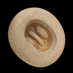 Detail view of woven straw hat interior featuring a comfortable beige sweatband and fiber texture