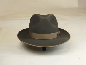 Detailed macro view of gray wool fedora hat with light brown decorative ribbon band