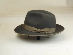 Detail of a dark gray wool fedora hat with a brown grosgrain ribbon and classic bow