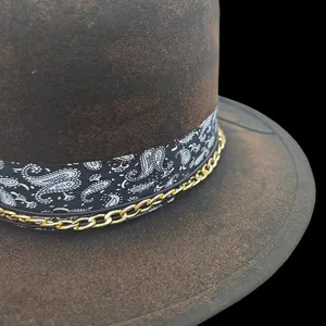 Détail du chapeau en laine avec ruban cachemire et chaîne dorée sur bord vieilli