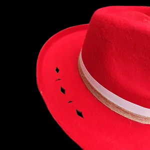 Detalle de sombrero de fieltro rojo con adorno de cinta y calados decorativos de rombos