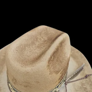 Close-up of distressed wool felt fedora with tribal jacquard band and feather detail