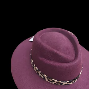 Detailed close-up of a purple wool fedora hat with a leopard print ribbon band