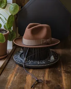 Detail of brown wool felt Fedora hat with ribbon band and braided wind lanyard closeup
