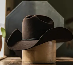 Primer plano detallado de sombrero vaquero de fieltro marrón con banda trenzada