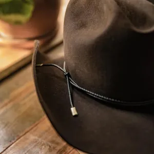 Sombrero de vaquero de fieltro marrón oscuro con cuerda decorativa trenzada y puntas