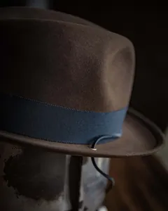 Close-up of wool felt Fedora hat with grosgrain ribbon and leather cord detail