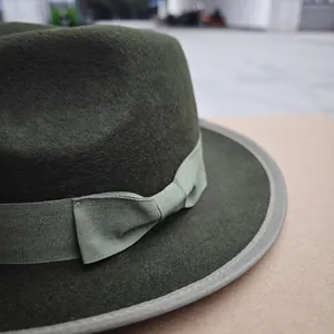 Close-up of wool fedora with ribbon detail and olive green textured finish