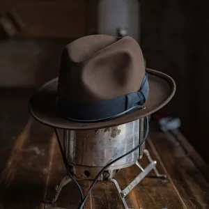 Classic brown wool felt fedora hat with black grosgrain ribbon on vintage metal stand