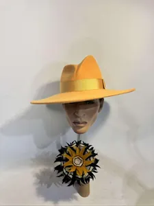 Detail of yellow wool felt fedora hat featuring a satin ribbon and feather accessory