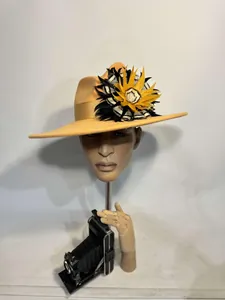 Macro shot of orange wool fedora with decorative feather floral ribbon detail