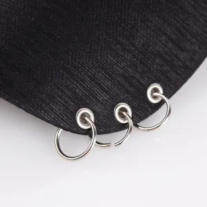 Detailed macro view of black twill baseball cap brim featuring three silver metal rings