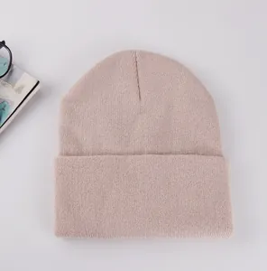 Detailed knit texture of light pink cuffed beanie with lifestyle accessories