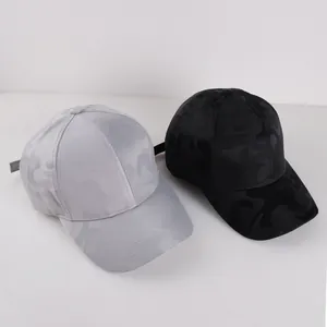 Detailansicht von Baseballkappen in Schwarz und Grau mit Tarnmuster und verstellbarem Band