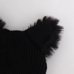 Black knitted cat ear beanie hat with fluffy faux fur details on a light grey background