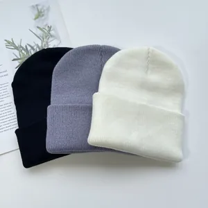 Gros plan détaillé de bonnets en maille côtelée en noir, gris et blanc pour l'automne-hiver