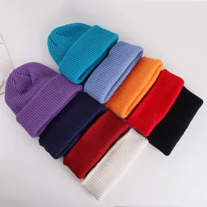 Flat lay of thick ribbed knit beanies in various colors including blue, red and beige