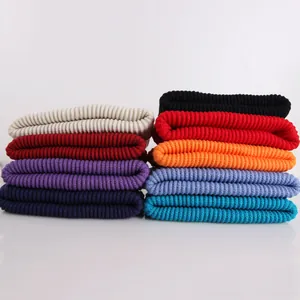 Detailed view of nine colorful ribbed knit beanies stacked in two neat vertical rows