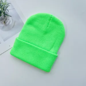 Gros plan détaillé du bonnet en maille côtelée vert fluo montrant la texture et le revers