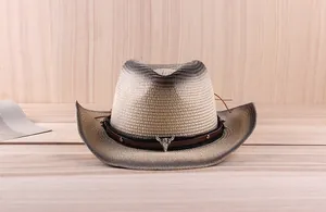 Detail of western straw cowboy hat featuring vintage leather band and silver bull head buckle