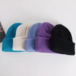 Detailed row of ribbed knit beanies in blue, white, purple and black colors