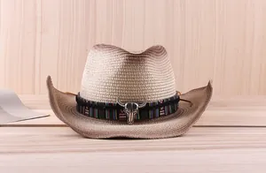 Close-up of vintage straw cowboy hat featuring a tribal band and metal bull head accessory