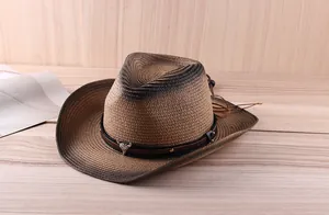 Close-up of a straw cowboy hat featuring a silver bull head metal logo on a leather band