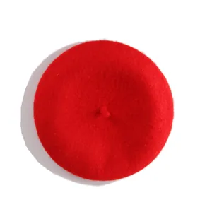 Top-down macro view of a vibrant red wool beret showing plush texture and center stalk