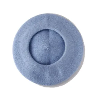 Close-up of light blue wool beret hat showing soft felt texture and top stem detail
