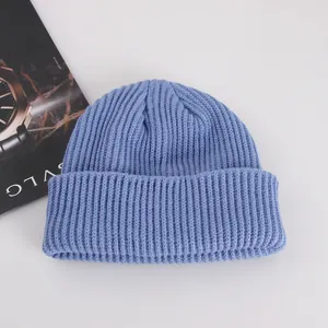 Detailed knit texture of light blue beanie with thick vertical stripes and wide cuff
