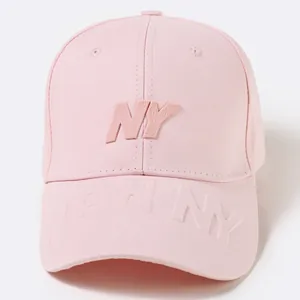 Detail of pink cotton baseball cap featuring raised rubber NY logo and embossed brim