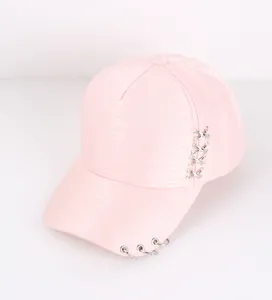 Detail of pink baseball cap featuring silver metal rings and crisscross lace-up side decor