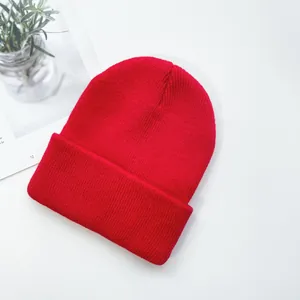 Gros plan détaillé sur la texture et les mailles fines du bonnet en tricot rouge vif