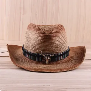 Vintage brown straw cowboy hat with colorful ribbon and metal bull head ornament
