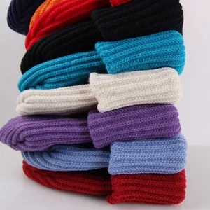 Detailed close-up of colorful knitted beanies showing thick ribbed texture and variety of colors