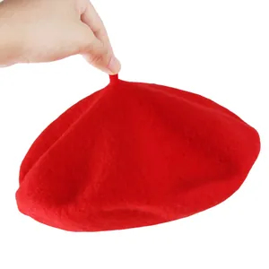 Classic bright red wool felt beret for girls with a top stem held against a white background