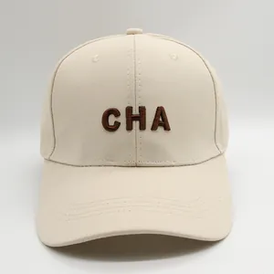 Detalle de gorra de algodón beige con bordado CHA marrón y costuras en la visera
