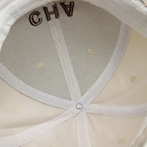 Detalle interior de gorra de béisbol crema con bordado CHV y costuras reforzadas